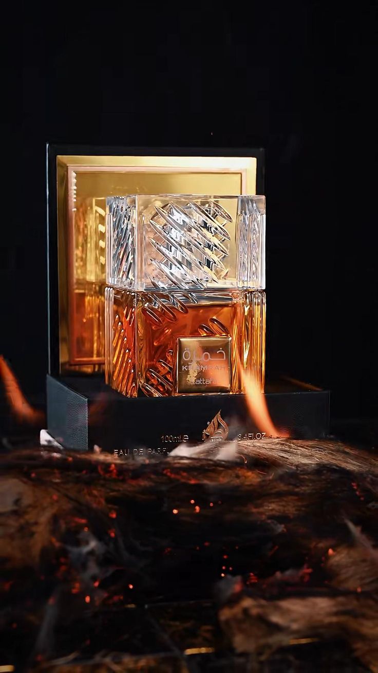 Lattafa Khamrah bottle on its box surrounded by embers